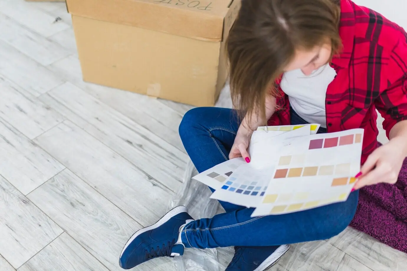 Von oben: Eine Frau betrachtet Farbmuster.